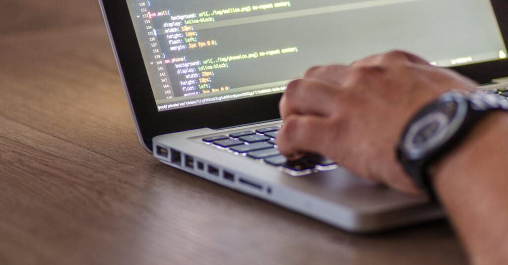 A close-up shot of a person coding on a laptop, focusing on the hands and screen.